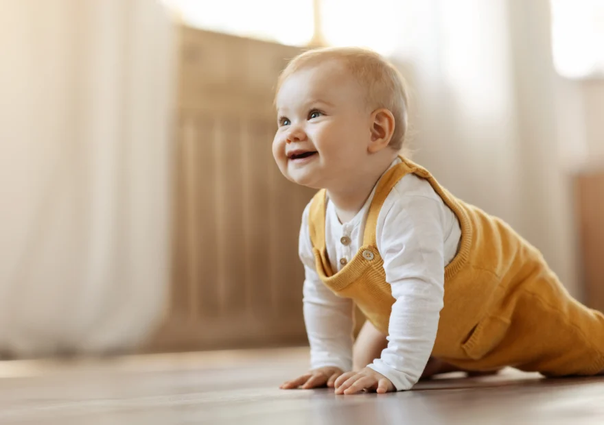 Glad bebis leker på ett golv städat med giftfri rengöring